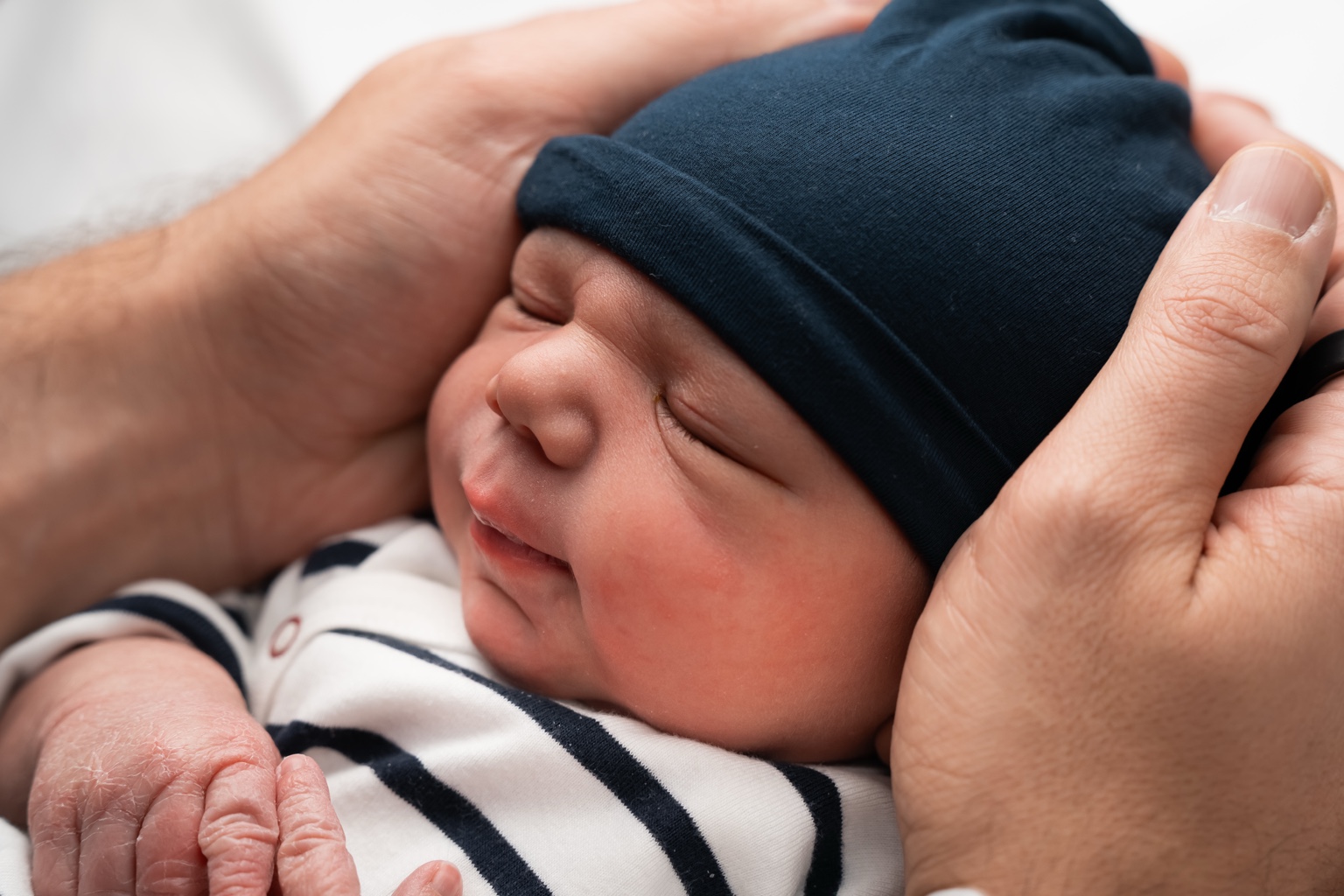 A close-up of Eden Mousani Cohen in his parents’ hands